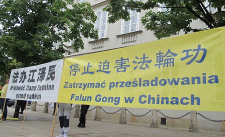 波兰法轮功学员在华沙总统府外面手持条幅，和平请愿。（黄诃欧/大纪元）